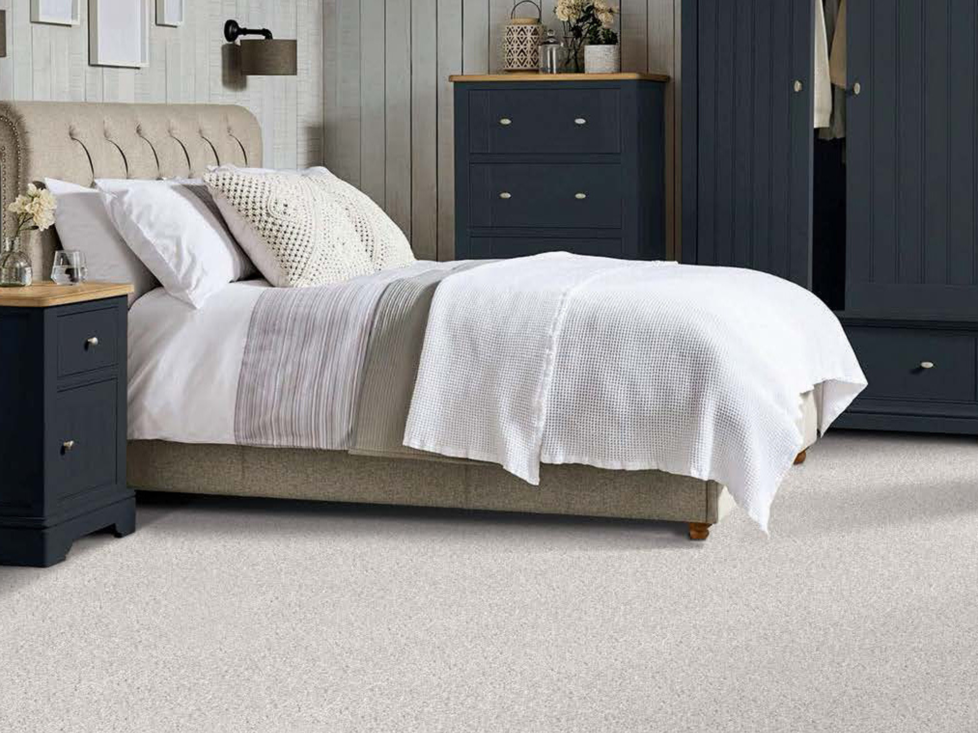 Beige carpet in a bedroom with black wooden furniture